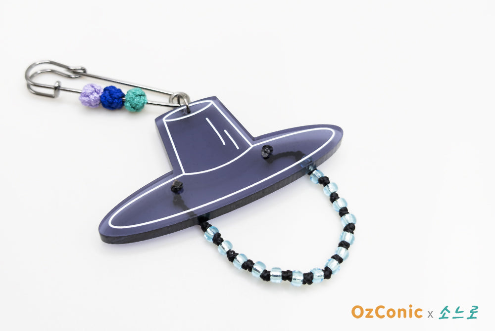 Purple spaceship keychain with a beaded chain on a white background