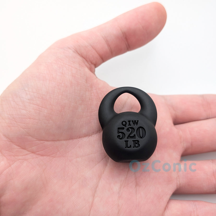 Small black weight plate held in a hand with 'OzConic' branding.